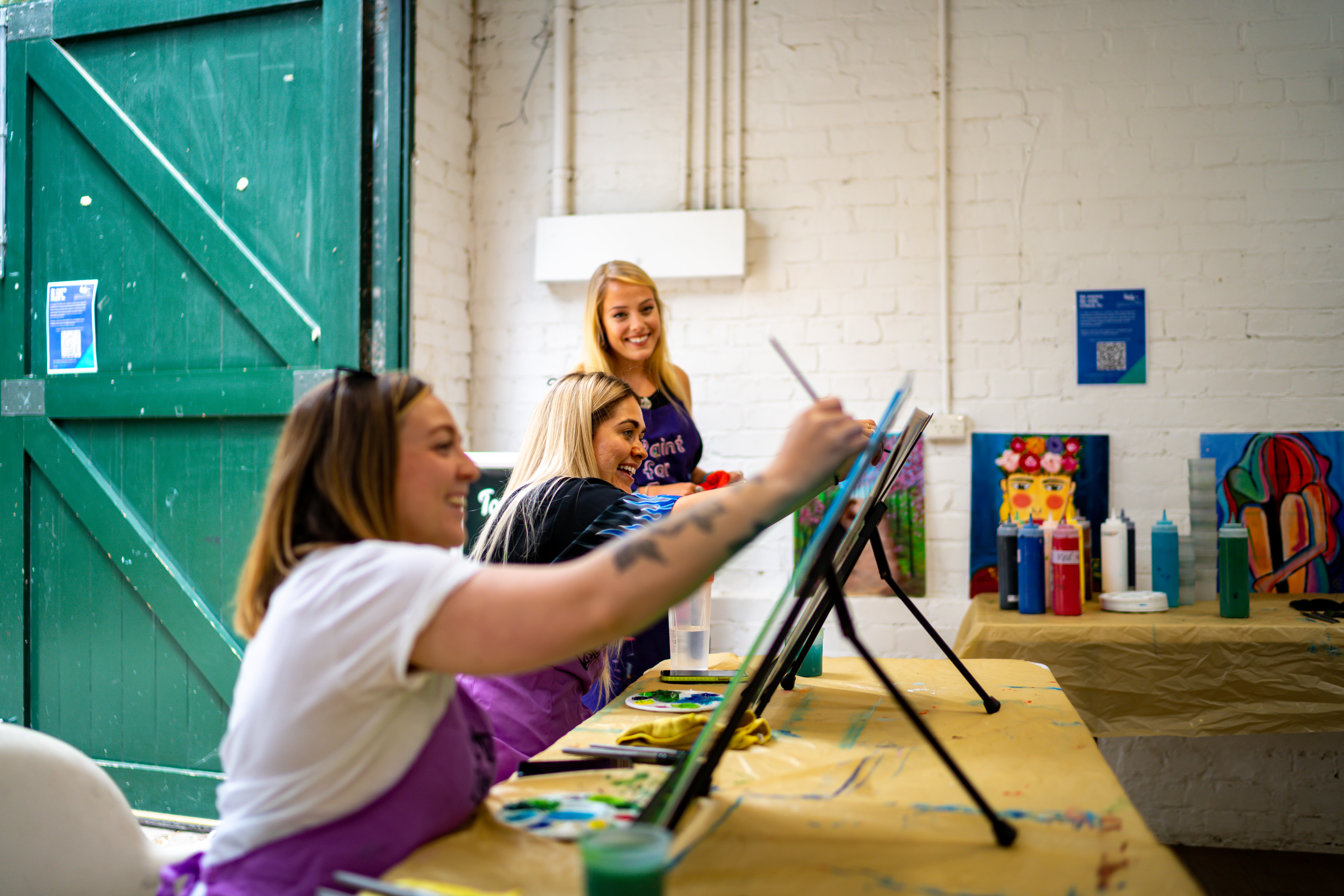 A group of women smiling at a paint and sip class